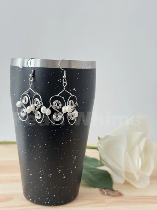 Close-Up of Coil Echo Earrings – Hand-Wrapped Stainless Steel Figure-Eight Coils Cradling Irregular Pearls, Hypoallergenic Jewelry Detail